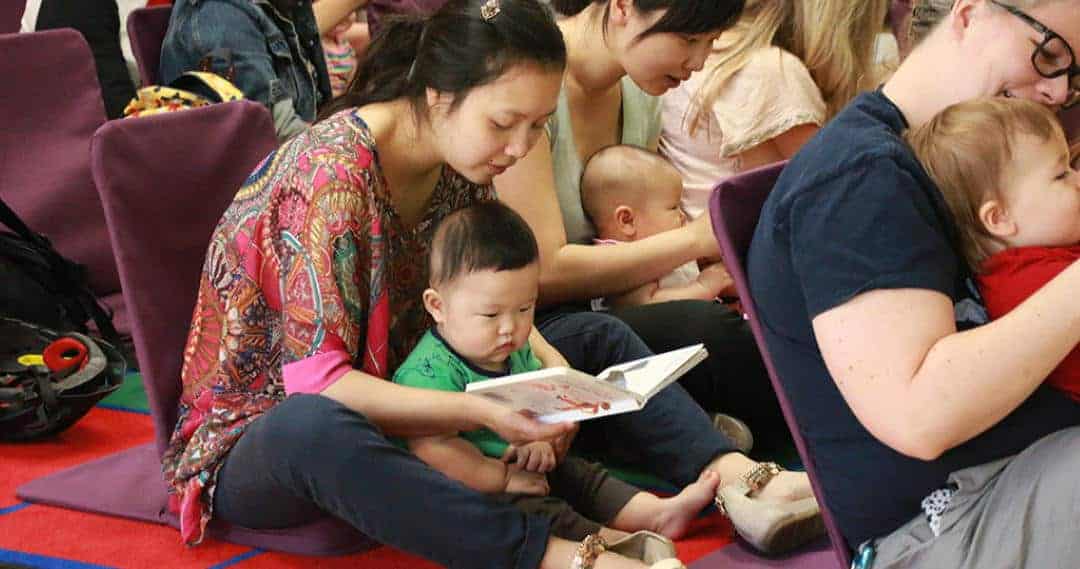 parents and babies reading books together