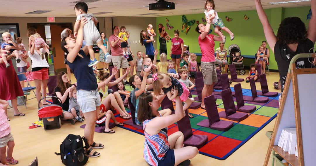 parents lifting toddlers up during storytime